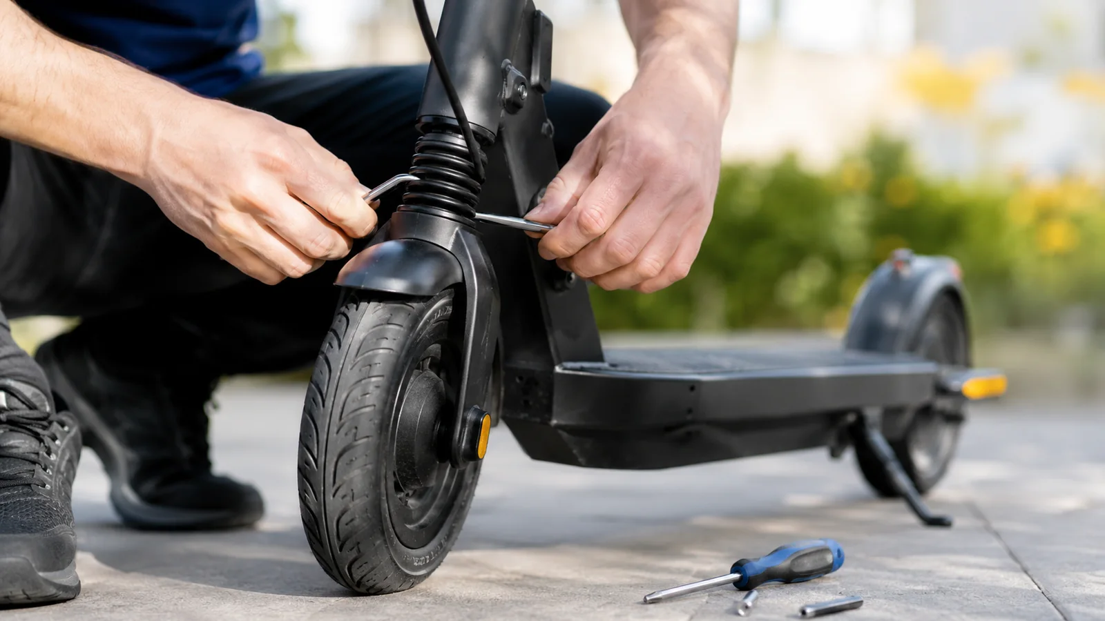 Hände stellen Federung und Reifen eines E-Scooters ein – Komfortprobleme lösen