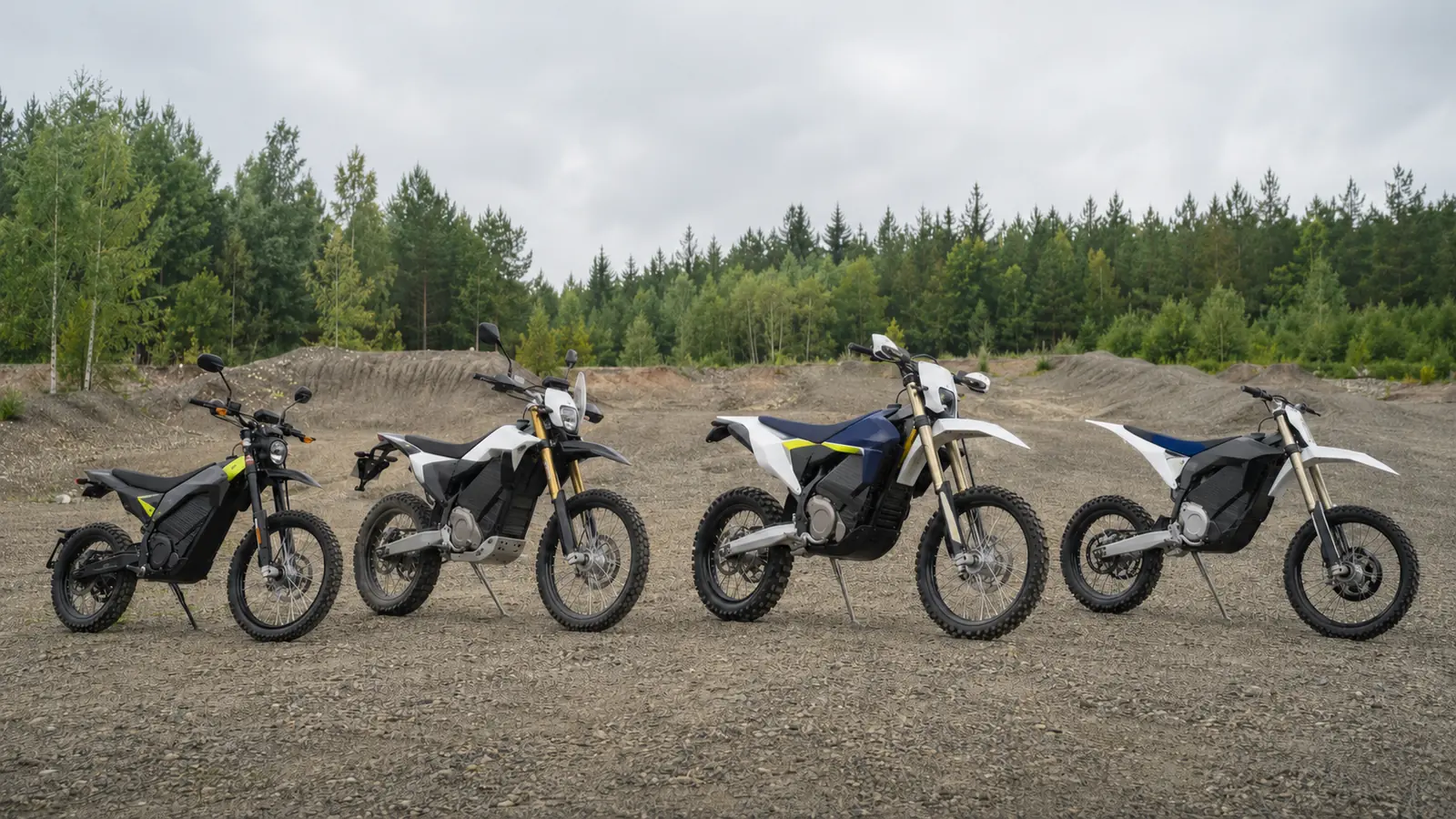 Vier Elektro-Enduros unterschiedlicher Klassen nebeneinander auf einem Geländeplatz
