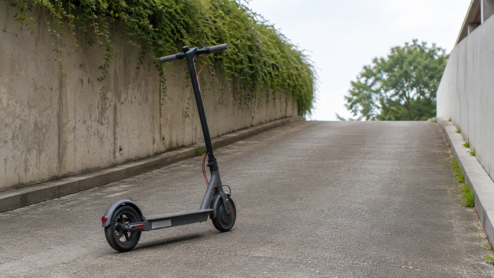 E-Scooter steht an leichter Rampe mit Steigung, sachliche Darstellung schwacher Leistung bergauf