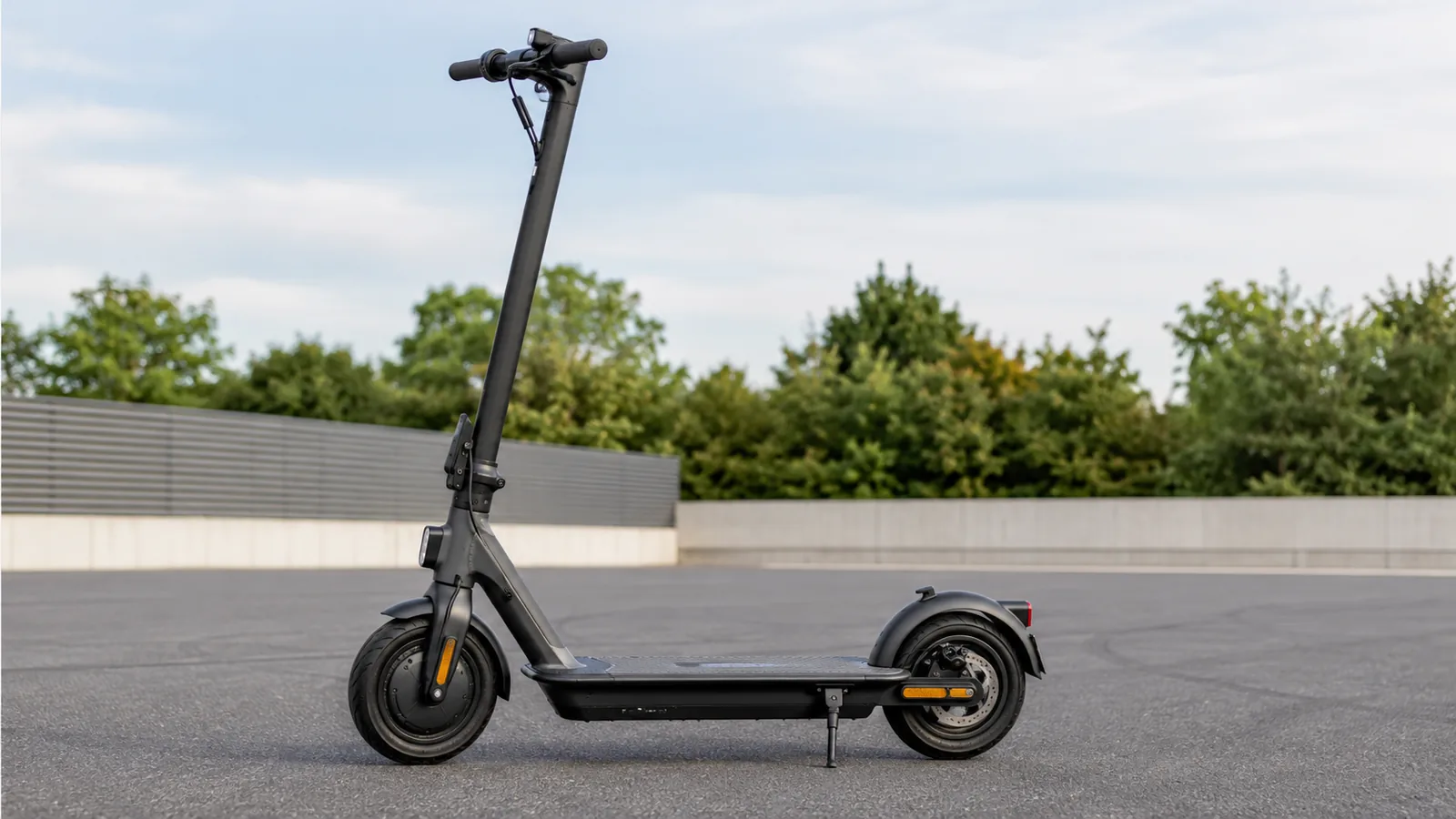 Schwarzer E-Scooter allein auf asphaltierter privater Testfläche ohne Smartphone, sachlicher Gerätebezug
