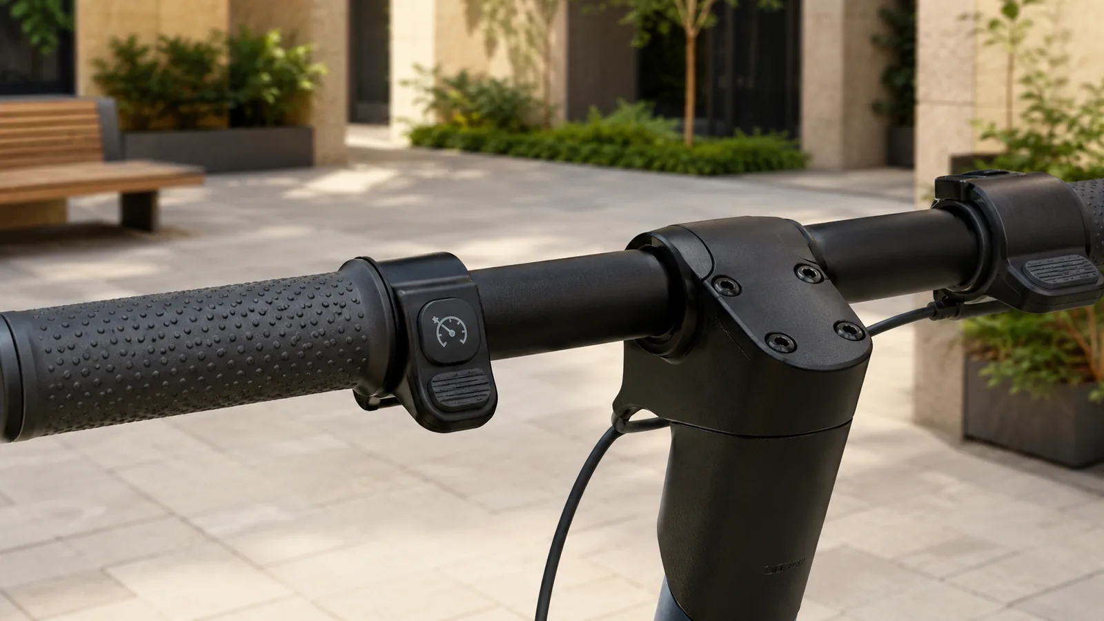 Nahaufnahme E-Scooter-Lenker mit Bedientaste und Tempomat-Symbol