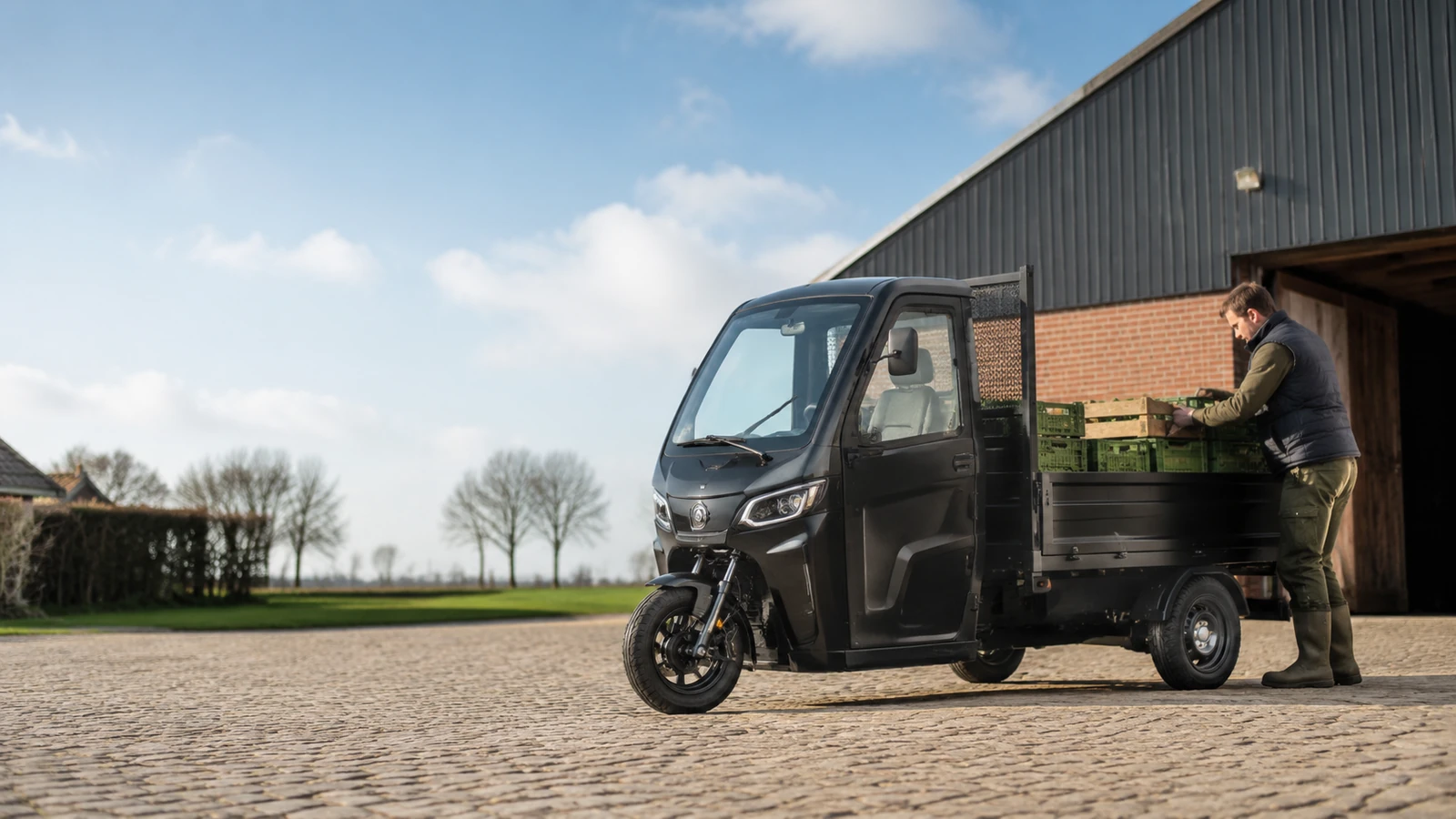 Elektrisches Tuktuk als E-Lastendreirad auf einem Hof beim Beladen