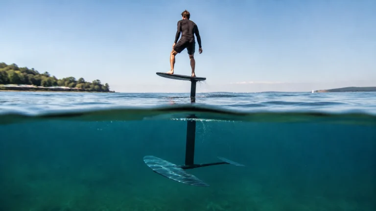 Foil-Board schwebt beim Foilen über dem Wasser, nur der Hydrofoil-Mast bleibt eingetaucht