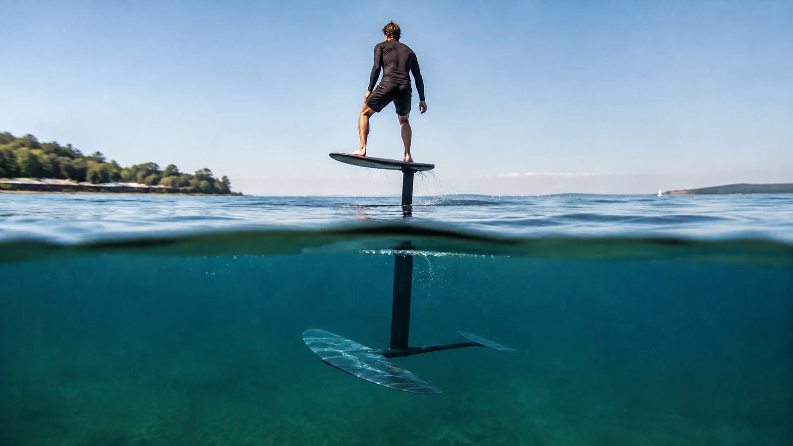 Foil-Board schwebt beim Foilen über dem Wasser, nur der Hydrofoil-Mast bleibt eingetaucht